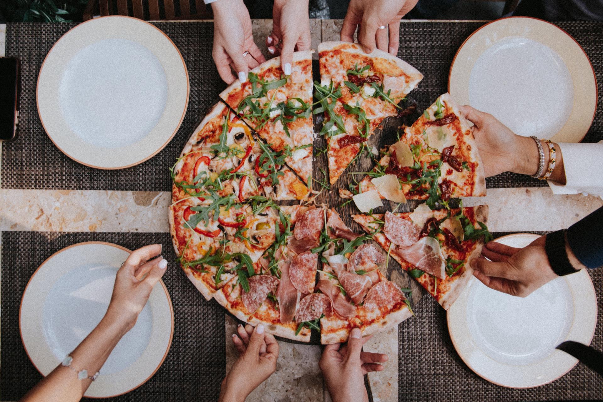 Family sharing pizza while on holiday in Italy